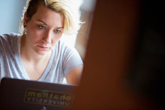 Photo of a Chatham University student working at her laptop in Cafe Rachel