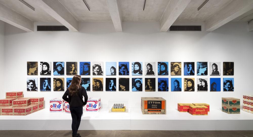 Photo of a person examining artwork at the Andy Warhol Museum