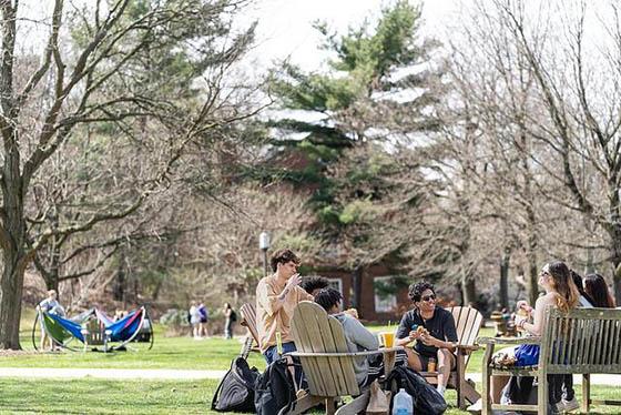 Photo of students sitting outside and hanging out on the Quad on Chatham University's Shadyside Campus